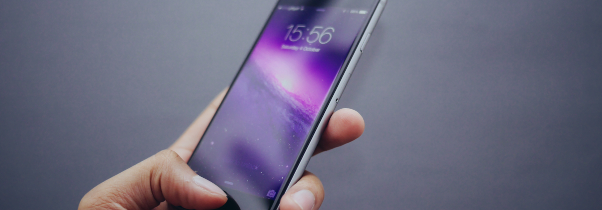 Person using thumb print to unlock iPhone