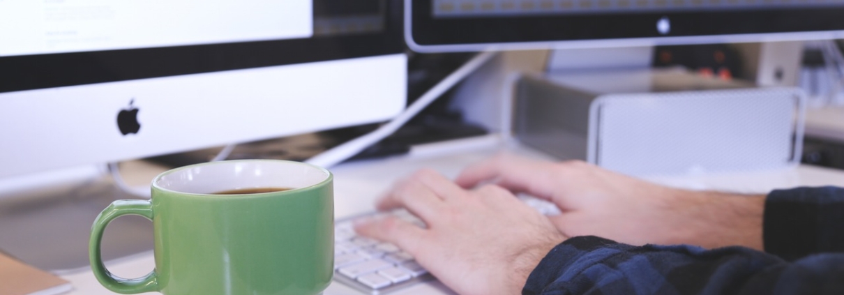 Man working on multi monitor computer