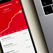 Cellphone showing a rising line graph on a red background