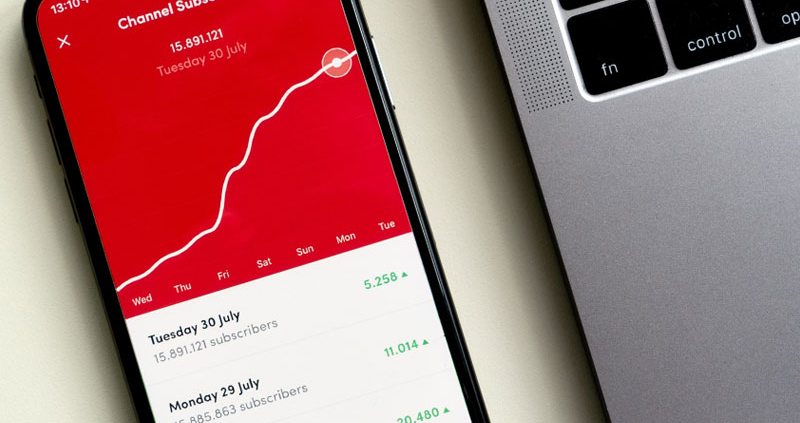 Cellphone showing a rising line graph on a red background