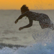 Surf boarder falling off board and into ocean