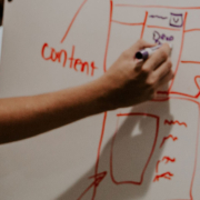 Person making website mockup on whiteboard