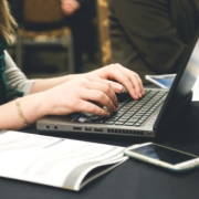 Woman with her hands on a laptop about to write.
