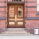 Brown and gold doorway set in brick building