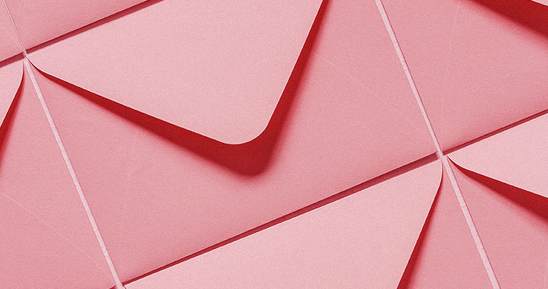 Multiple pink envelopes laid out side by side
