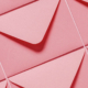 Multiple pink envelopes laid out side by side