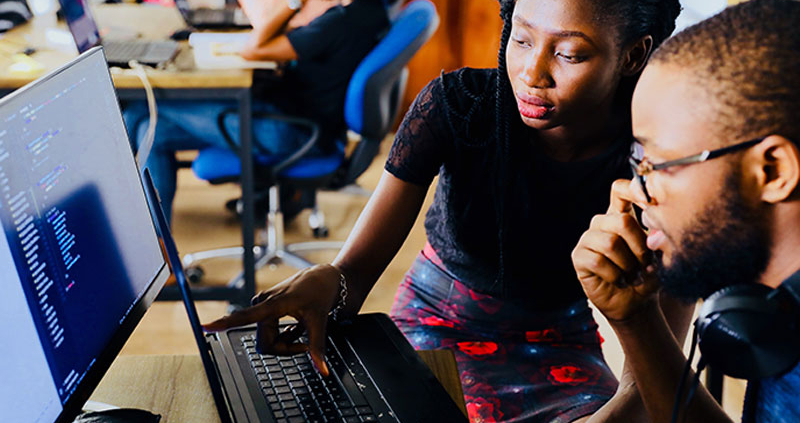 Man and woman looking and pointing at computer screen