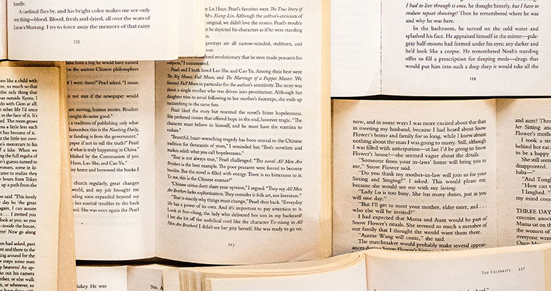 Multiple open books stacked on top of and next to each other