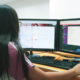 Woman working on two computer screens