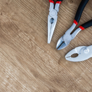 Pliers and snippers on a wood background