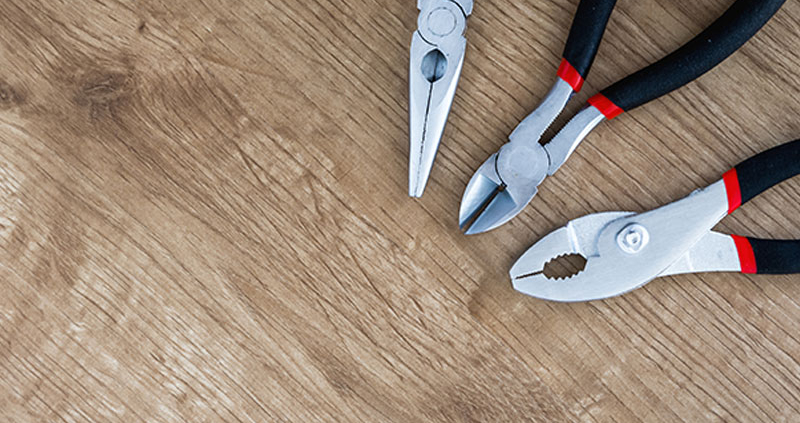 Pliers and snippers on a wood background