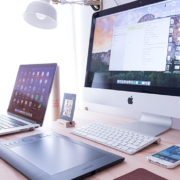 Desk with laptop, desktop, phone, and tablet