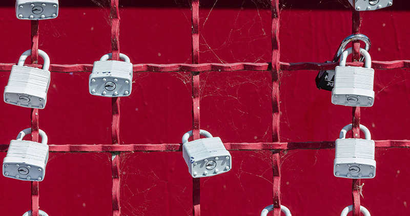 White padlocks on a red fence