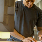 Man jotting down notes next to a computer