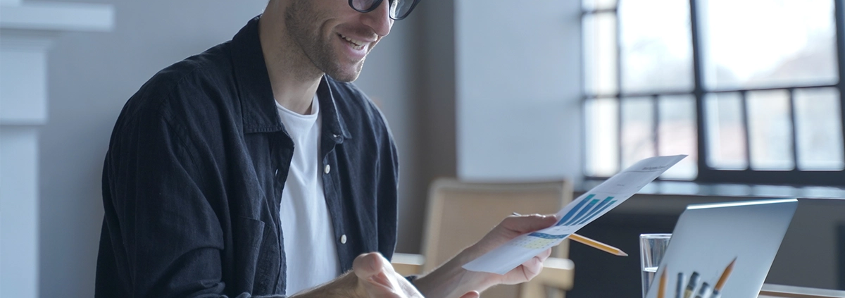A young man working from home has a video meeting on his computer.