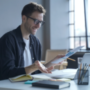 A young man working from home has a video meeting on his computer.