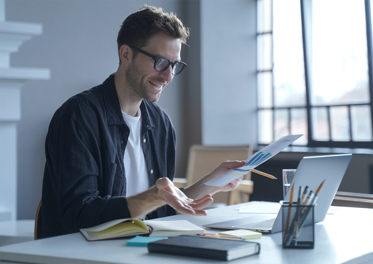 workingFromHome A young man working from home has a video meeting on his computer.
