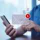 An illustration showing a man holding his phone with a new email notification.