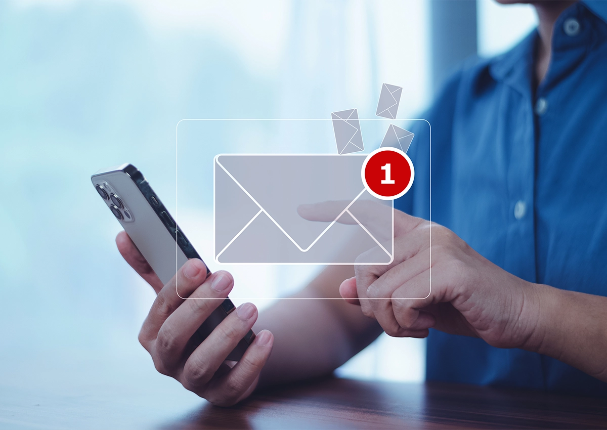 An illustration showing a man holding his phone with a new email notification.