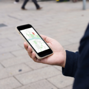A person holding a cell phone with Google Maps on the screen.