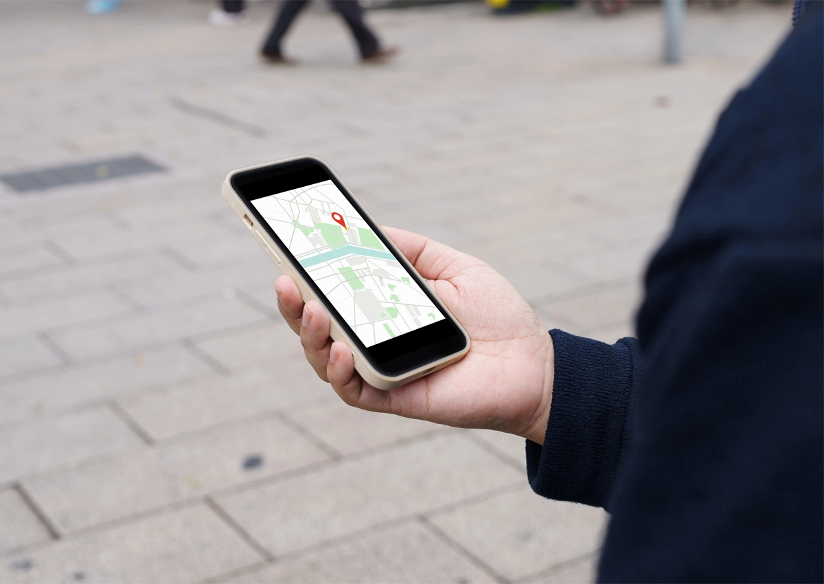 A person holding a cell phone with Google Maps on the screen.