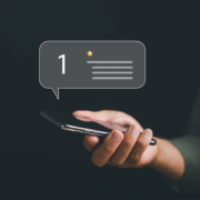 A woman holding a phone depicting a one-star review.